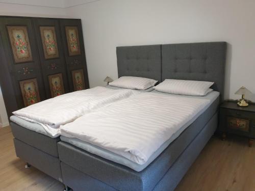 een groot bed met witte lakens en kussens erop bij Hotel Restaurant Bauernstube in Eschenburg