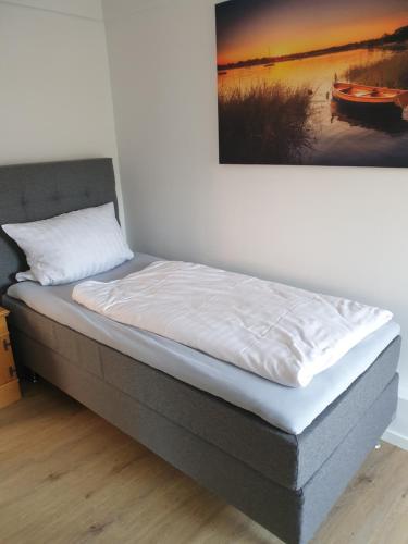 a bed in a room with a painting on the wall at Hotel Restaurant Bauernstube in Eschenburg