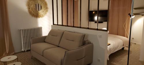 een woonkamer met een stoel en een bed bij auberge le petit mas in Issoire