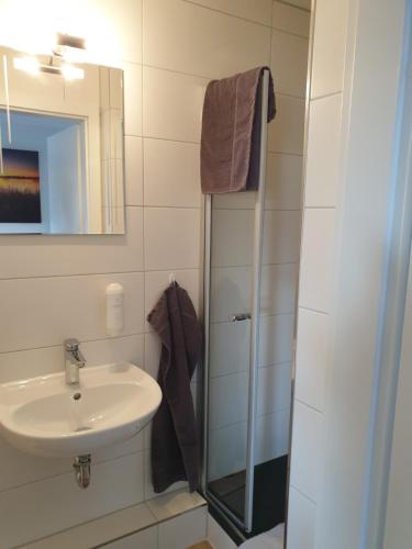 La salle de bains est pourvue d'un lavabo et d'une douche. dans l'établissement Hotel Restaurant Bauernstube, à Eschenburg