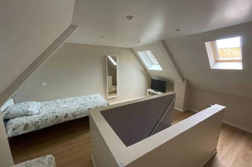 - une chambre mansardée avec un lit et une télévision dans l'établissement Appartement cosy, wifi gratuit,5 min de la gare, à Boulogne-sur-Mer