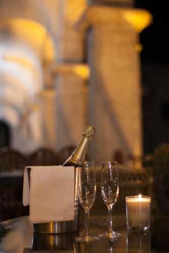 a table with a bottle of champagne and two wine glasses at La Plaza Arequipa Hotel Boutique in Arequipa