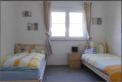 um quarto com 2 camas e uma janela em FeWo Aida em Stockach