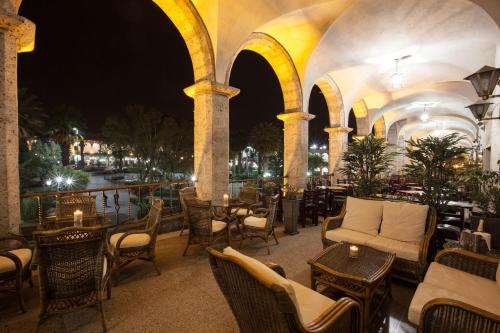 an outdoor patio with tables and chairs at night at La Plaza Arequipa Hotel Boutique in Arequipa