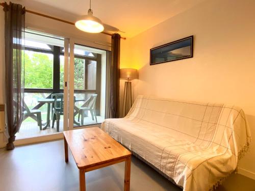 een slaapkamer met een bed en een tafel en een balkon bij REF 042 Appartement T2 avec balcon et piscine Arzon in Arzon