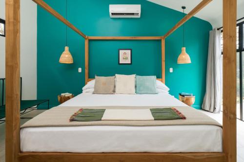 a bedroom with a large bed with a blue wall at Favela Chic Tamarindo - Adults Only in Tamarindo