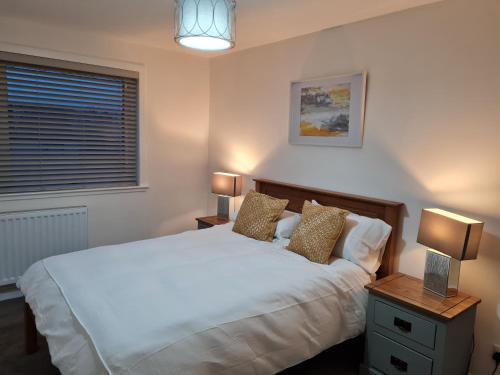 a bedroom with a white bed and two lamps at No 14 in Wick