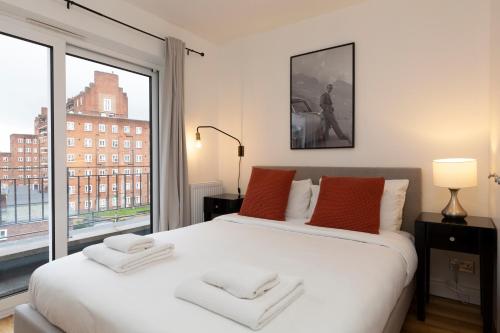 a bedroom with a large white bed with a large window at Deluxe Central London Camden in London