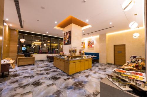 a restaurant with a counter in the middle of a room at The Fern Residency, Jamnagar in Jamnagar