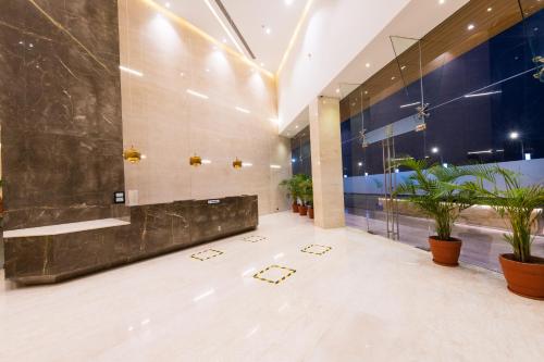 een lobby van een hotel met potplanten bij The Fern Residency, Jamnagar in Jamnagar