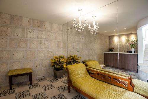 a living room with a couch and a chandelier at La Plaza Arequipa Hotel Boutique in Arequipa