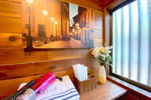 a table with a vase of flowers next to a window at Youan in Fujikawaguchiko