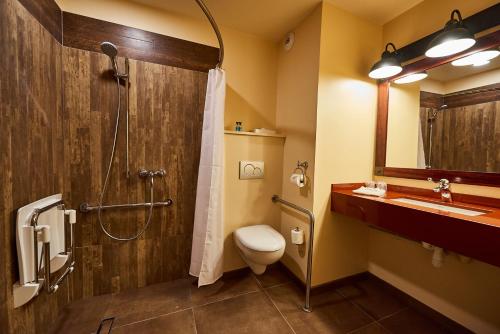 a bathroom with a shower and a toilet and a sink at Disney Hotel Cheyenne in Coupvray