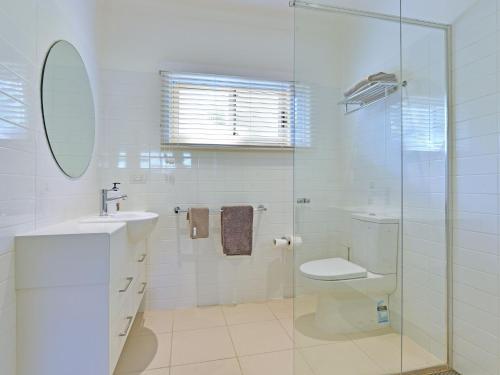 a bathroom with a toilet and a sink and a shower at Wangi Lakehouse in Wangi Wangi