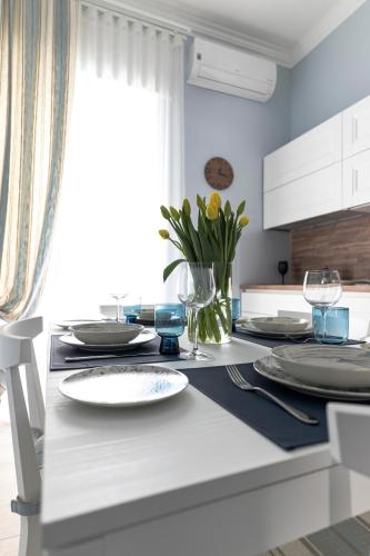 a kitchen with a table with plates and flowers on it at Azzurro 6 Holiday House in Martina Franca