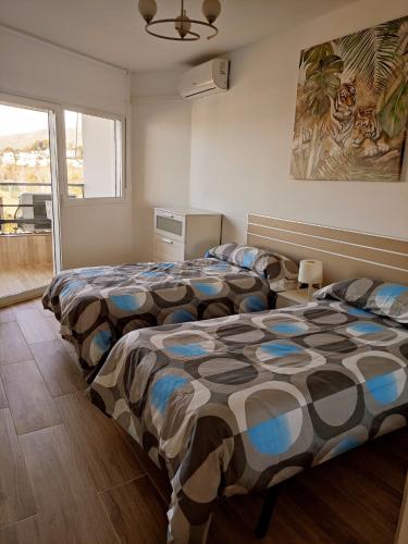 sypialnia z dwoma łóżkami i oknem w obiekcie MALAGUEÑA VIEWS w mieście Torremolinos