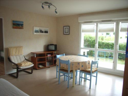 un salon avec une table et des chaises de salle à manger dans l'établissement REF 197 Appartement T3 sur le Port du Crouesty, à Arzon