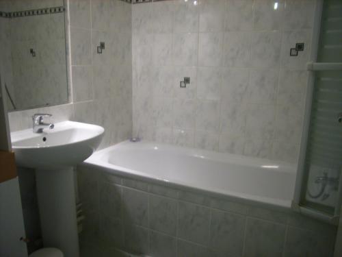 une salle de bain avec une baignoire blanche et un lavabo dans l'établissement REF 197 Appartement T3 sur le Port du Crouesty, à Arzon