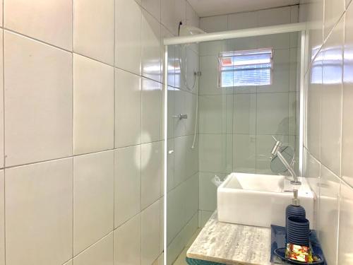 a white bathroom with a sink and a shower at Temporada Litorânea slz in São Luís