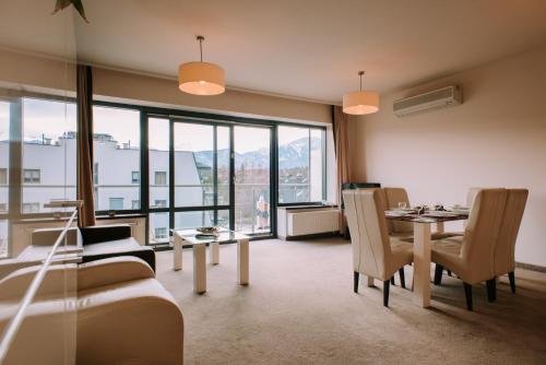a living room with a table and chairs and a large window at Szklane Domy in Zakopane