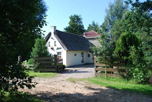 a white house with a gate and a fence at Vakantiehuis "It koaihûs" in Jistrum