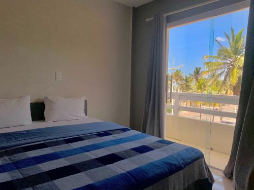 a bedroom with a bed and a large window at Temporada Litorânea slz in São Luís