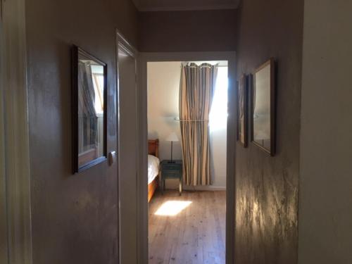 a hallway with a door to a bedroom with a bed at Adorable Penty en pierres en bord de mer in Tréogat