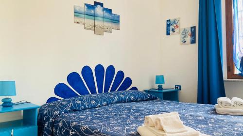 - une chambre avec un lit bleu et 2 tables bleues dans l'établissement Sa dommo de Mammai, à Cala Gonone