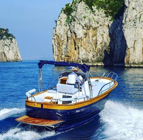 a man is driving a boat in the water at 5 terre dei poeti in La Spezia