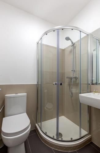 a bathroom with a shower and a toilet and a sink at Deluxe Central London Camden in London