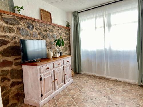 TV en un armario de madera en una habitación con ventana en CasaDina Apartment IUN Q2891, en Oschiri