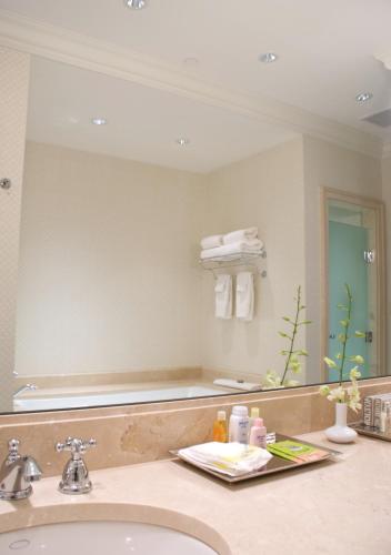 a bathroom with a sink and a large mirror at Capital Hotel in Little Rock