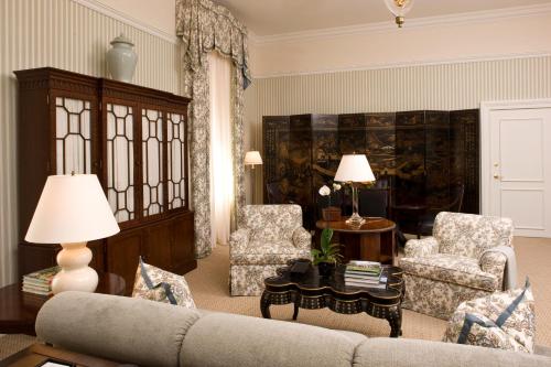 a living room with a couch and two chairs at Capital Hotel in Little Rock