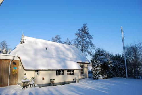a white house with snow on the roof at Vakantiehuis "It koaihûs" in Jistrum