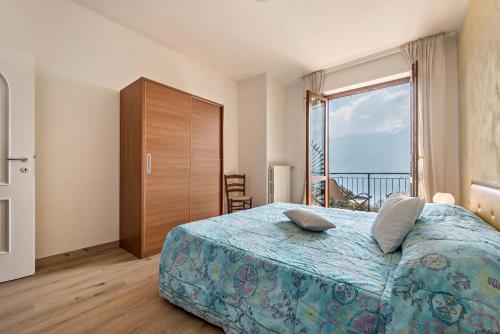 a bedroom with a large bed and a large window at Bel Soggiorno lake view 1 in Tremosine Sul Garda