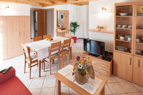 a kitchen and living room with a table and a television at Casa al Moro in Rocca Pietore