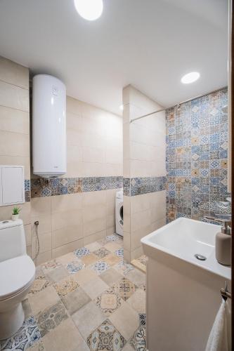 a bathroom with a tub and a toilet and a sink at Comfy luxury center apartment in Varna City