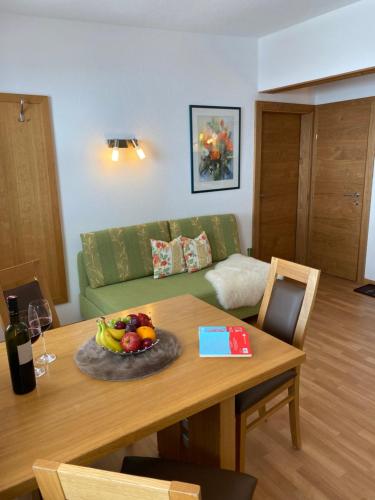 a living room with a table with a bowl of fruit at Apart Renate in Galtür
