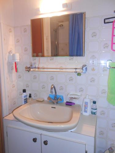 une salle de bain avec un lavabo et un miroir dans l'établissement Maison Palmeral, à Coustaussa