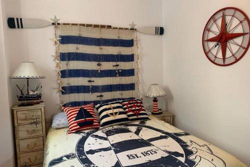 ein Schlafzimmer mit einem Bett mit zwei Lampen und einer Uhr in der Unterkunft Apartamento Paseo de la Carihuela in Torremolinos