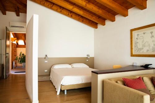 a bedroom with a bed and a couch at Residence Regina dei Prati in Mason Vicento