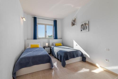 1 dormitorio con 2 camas y ventana en Flatguest Trebolina - 3Bdr - FastWiFi - Parking, en Vecindario