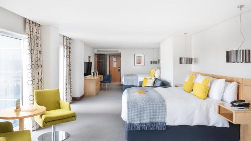 a hotel room with two beds and a table and chairs at voco Reading in Reading