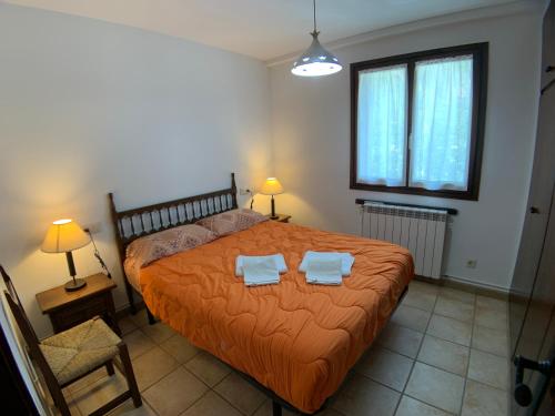 a bedroom with a bed with two towels on it at B36 - Mayor 48, 1º - Villmor in Benasque