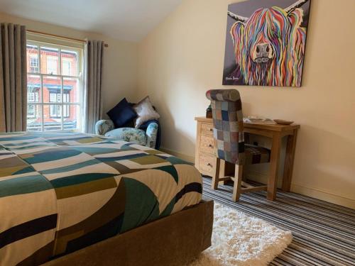 a bedroom with a bed and a painting of a dog at Unicorn Hotel in Llanidloes