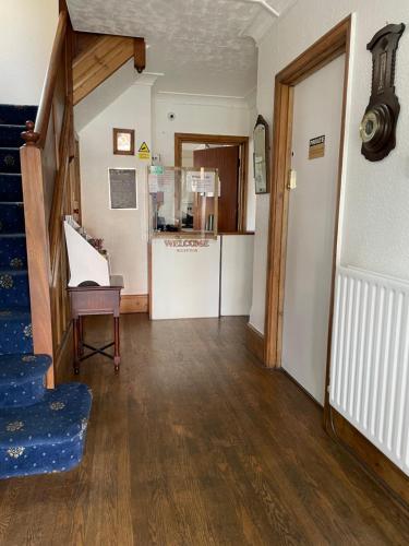 a living room with a staircase and a kitchen at Whiteways Guest House in Skegness