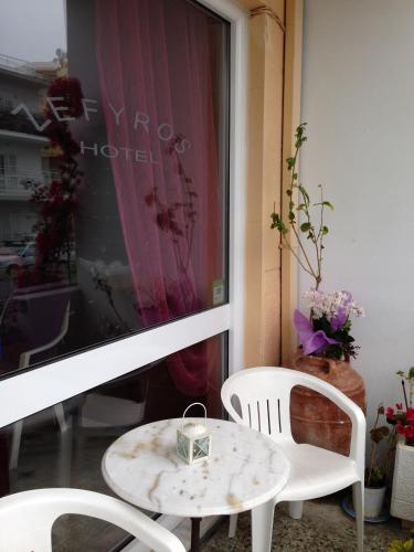 a table and two chairs in front of a window at Zefyros Hotel in Rhodes Town