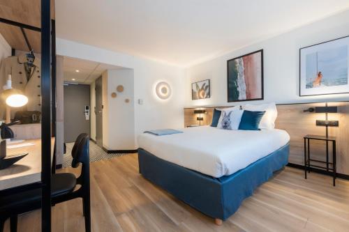 a hotel room with a bed and a desk at Tulip Residences Joinville-Le-Pont in Joinville-le-Pont