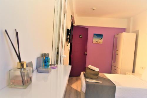 sala de estar con paredes de color púrpura y mesa en Lavender Otel, en Cesme