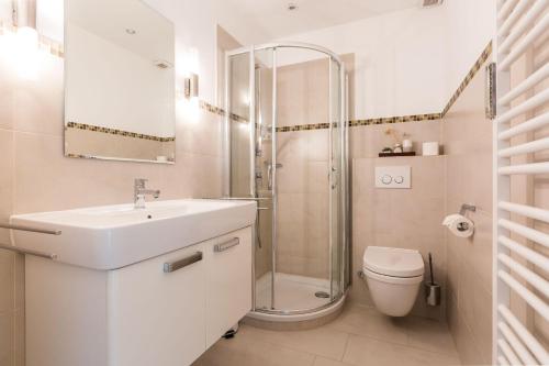 a white bathroom with a sink and a shower at Haus Weesterhuk Whg 8 in Keitum
